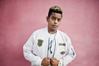 Şık hipster Arap adam adam sokakta açık poz verdi. Stil rap şarkıcısı pembe duvara.