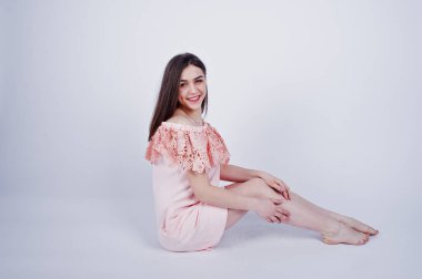 Oturma ve stüdyoda katta poz pembe elbiseli şık bir kadın portresi.