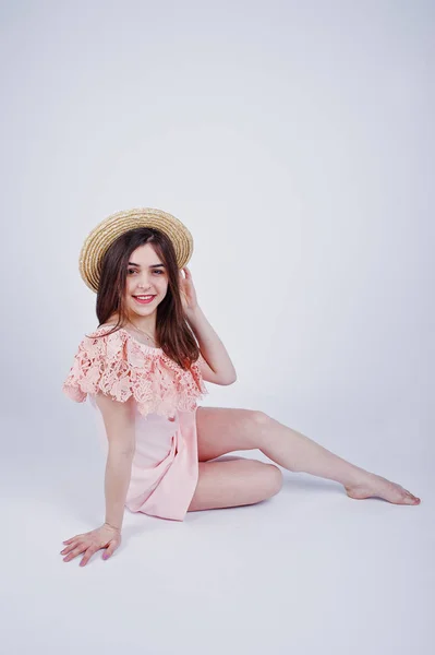 座ってポーズ スタジオの床に帽子とピンクのドレスでファッショナブルな女性の肖像画 — ストック写真