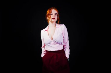 Bir kızıl saçlı kız pembe bluz ve siyah arka plan üzerine marsala etek portresi.