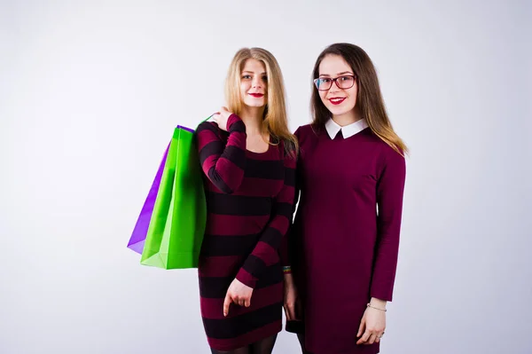 Två Vackra Vänner Cherry Klänningar Poserar Med Mångfärgade Shoppingkassar Studion — Stockfoto