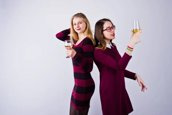 两个有魅力的朋友在紫色礼服喝汽酒或香槟在演播室 — 图库照片