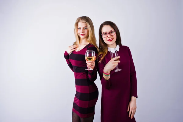 两个有魅力的朋友在紫色礼服喝汽酒或香槟在演播室 — 图库照片