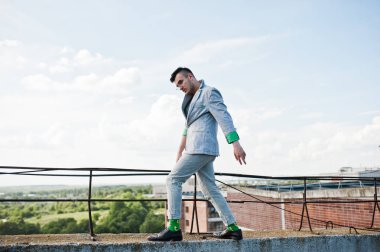 Gri takım elbise ve gözlük hayalperest şık maço adam çatıda poz verdi.. 