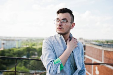 Gri takım elbise ve gözlük hayalperest şık maço adam çatıda poz verdi.. 