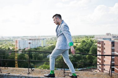 Gri takım elbise ve gözlük hayalperest şık maço adam çatıda poz verdi.. 