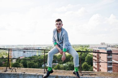 Gri takım elbise ve gözlük hayalperest şık maço adam çatıda poz verdi.. 