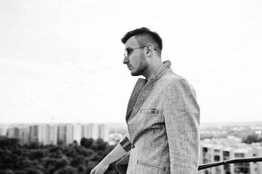 Gri takım elbise ve gözlük hayalperest şık maço adam çatıda poz verdi.. 