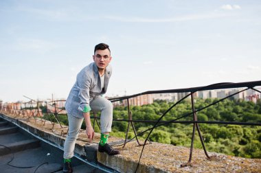 Gri takım elbise ve gözlük hayalperest şık maço adam çatıda poz verdi.. 