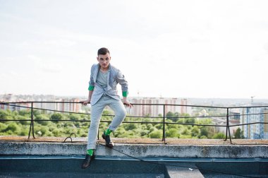 Gri takım elbise ve gözlük hayalperest şık maço adam çatıda poz verdi.. 