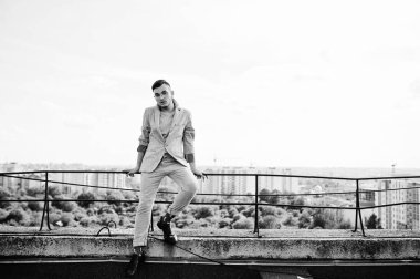 Gri takım elbise ve gözlük hayalperest şık maço adam çatıda poz verdi.. 