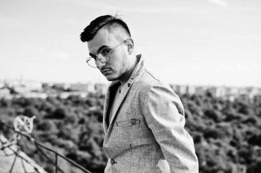 Gri takım elbise ve gözlük hayalperest şık maço adam çatıda poz verdi.. 