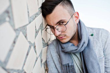 Gri takım elbise, eşarp ve gözlük hayalperest şık maço adam çatıda poz verdi.. 