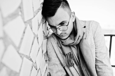 Gri takım elbise, eşarp ve gözlük hayalperest şık maço adam çatıda poz verdi.. 