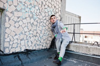 Gri takım elbise, eşarp ve gözlük hayalperest şık maço adam çatıda poz verdi.. 