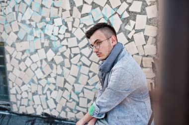 Gri takım elbise, eşarp ve gözlük hayalperest şık maço adam çatıda poz verdi.. 