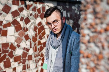 Gri takım elbise, eşarp ve gözlük hayalperest şık maço adam çatıda poz verdi.. 