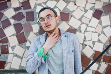 Gri takım elbise, şapka ve gözlük hayalperest şık maço adam çatıda poz verdi.. 