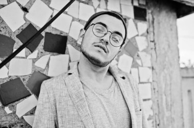 Gri takım elbise, şapka ve gözlük hayalperest şık maço adam çatıda poz verdi.. 