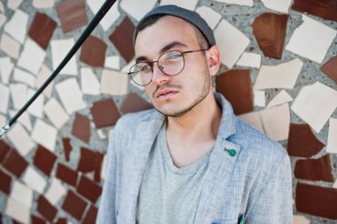 Gri takım elbise, şapka ve gözlük hayalperest şık maço adam çatıda poz verdi.. 