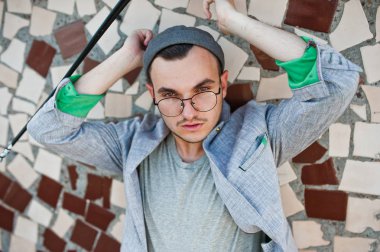 Gri takım elbise, şapka ve gözlük hayalperest şık maço adam çatıda poz verdi.. 