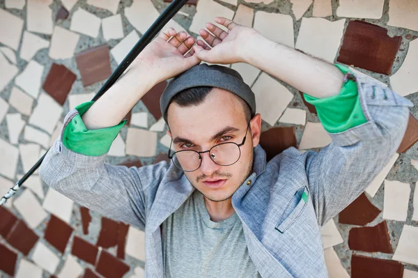 Gri takım elbise, şapka ve gözlük hayalperest şık maço adam çatıda poz verdi.. 