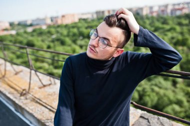 Hayalperest şık maço erkek siyah golf ve gözlük çatıda poz verdi..