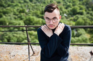 Hayalperest şık maço erkek siyah golf ve gözlük çatıda poz verdi..