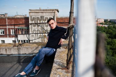 Hayalperest şık maço erkek siyah golf ve gözlük çatıda poz verdi..