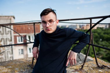 Hayalperest şık maço erkek siyah golf ve gözlük çatıda poz verdi..