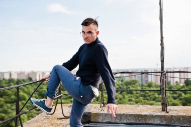 Hayalperest şık maço erkek siyah golf ve gözlük çatıda poz verdi..