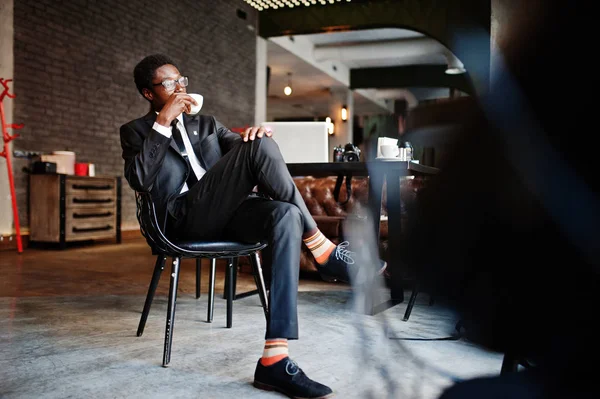 Business african american man wear on black suit and glasses at office, drinking morning coffee before work day.