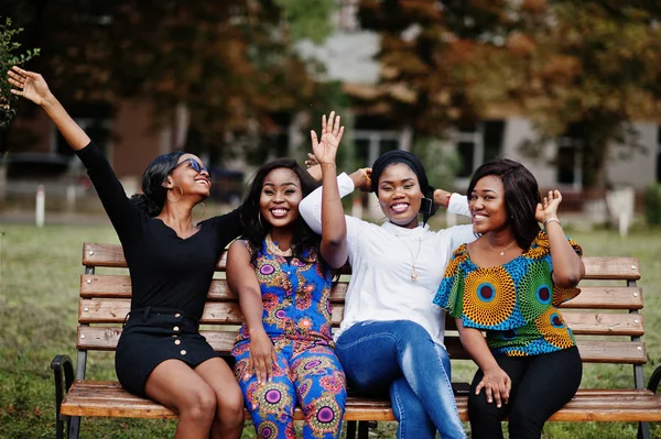 Dört Afro-Amerikan Kız tezgah açık ve koyun elleri havada oturma grubu.