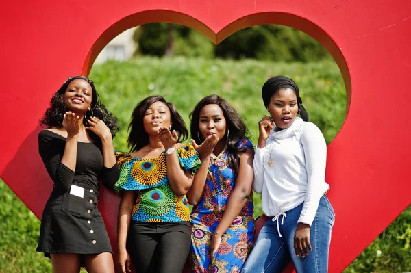 Büyük kırmızı kalp açık gönderen hava öpücük karşı dört Afro-Amerikan kız grubu.