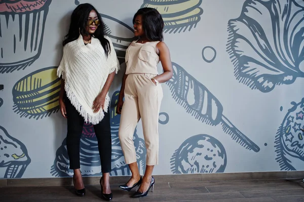 Twee Stijlvolle African American Meisjes Café Gesteld Tegen Muur — Stockfoto