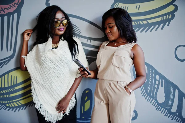 Twee Stijlvolle African American Meisjes Café Gesteld Tegen Muur — Stockfoto