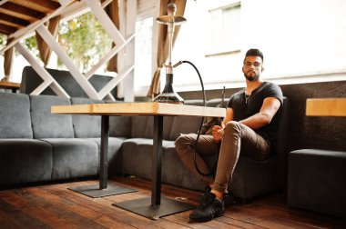 Arap adam gözlük ve siyah t-shirt sigara nargile sokak barında şık sakal. Geri kalan Arap modelinde.