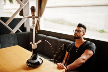 Arap adam gözlük ve siyah t-shirt sigara nargile sokak barında şık sakal. Geri kalan Arap modelinde.
