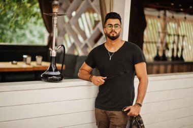 Arap adam gözlük ve siyah tişört sigara nargile açık şık sakal. Geri kalan Arap modelinde.