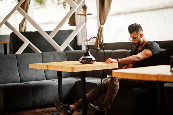 Arap adam gözlük ve siyah t-shirt sigara nargile sokak barında şık sakal. Geri kalan Arap modelinde.