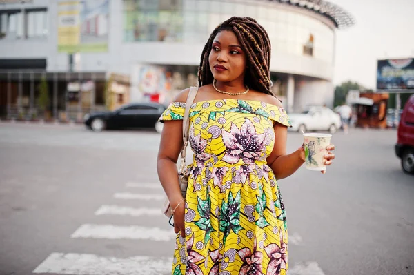 Sevimli küçük yükseklik dreadlocks, Afrikalı-Amerikalı kızla giymek renkli sarı elbise, Ticaret Merkezi ile kahve el altında karşı yaya geçidi, yürüyüş.
