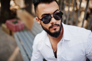 Beyaz gömlek ve güneş gözlükleri şık Arap adam model fotoğrafı kapatın. Sakal çekici Arap adam.