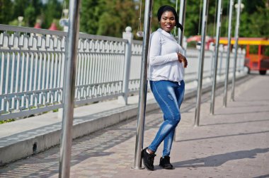 Afrika Müslüman kız siyah Tesettür, beyaz tişört ve kot pantolon açık poz verdi.