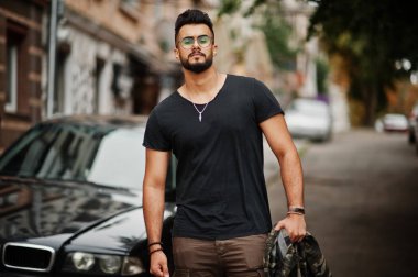 Harika güzel uzun boylu ararbian sakal maço erkek gözlük ve siyah tişört iş araba karşı yürüyüş.