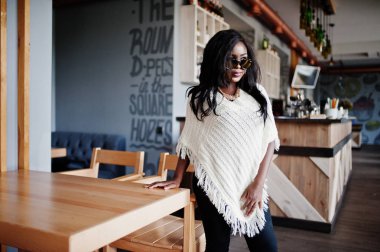 Güneş gözlüğü şık Afro-Amerikan Kız modern café'de poz verdi..