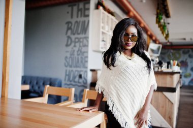 Güneş gözlüğü şık Afro-Amerikan Kız modern café'de poz verdi..
