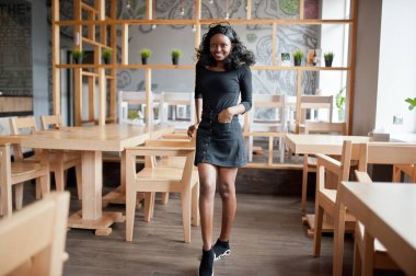 Afro-Amerikan Kız ahşap modern café'de poz verdi..