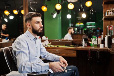 Yakışıklı sakallı adam kuaför berber, sandalye üzerinde oturan.