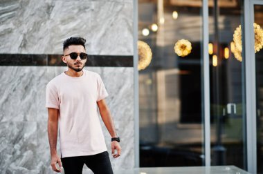 Güneş gözlüğü ve pembe tişört şık Hint sakallı adam. Hindistan modeli şehrin sokaklarında, açık poz verdi.