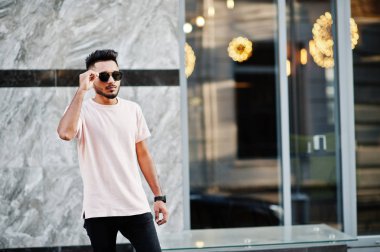 Güneş gözlüğü ve pembe tişört şık Hint sakallı adam. Hindistan modeli şehrin sokaklarında, açık poz verdi.